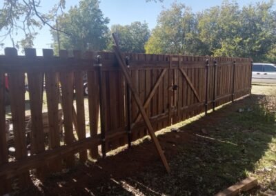 Newly installed custom wooden gate and fence with fresh staining by Wichita Falls Fence & Stain Co