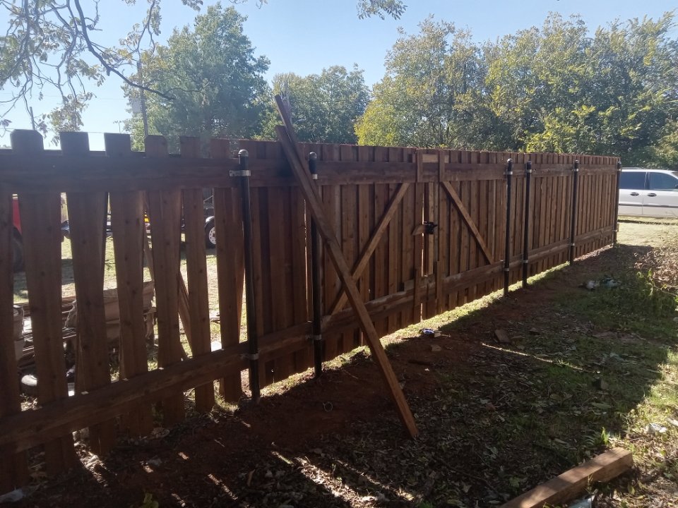 Newly installed custom wooden gate and fence with fresh staining by Wichita Falls Fence & Stain Co